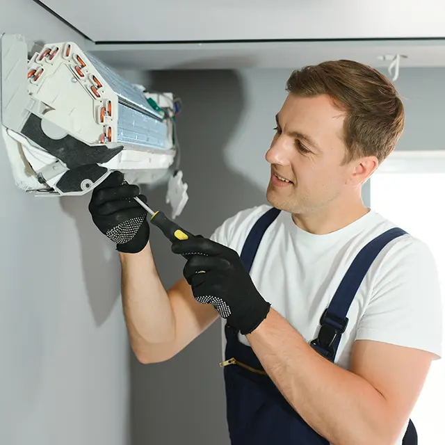 air conditioning services, AC Repair in Northwest Arkansas - AR as a technician tests a condenser during a summer breakdown, AC Repair in Lowell - AR as a technician tests voltage at an outdoor condenser